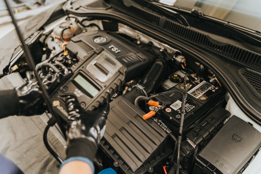 pexels photo 13065689 Close-up view of a mechanic diagnosing a Volkswagen engine with specialized equipment.