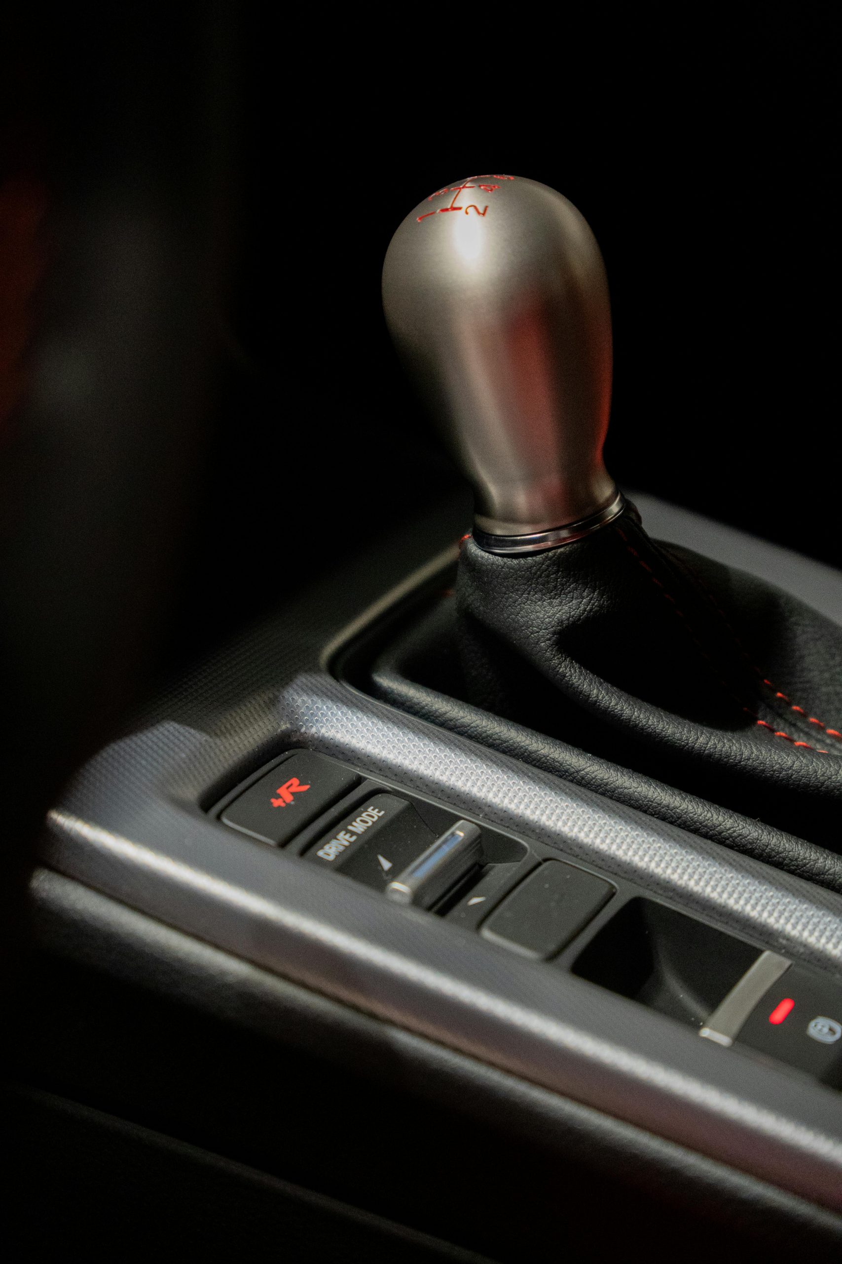 Vertical close-up of a modern automobile gear shifter with focus on design and detail.
