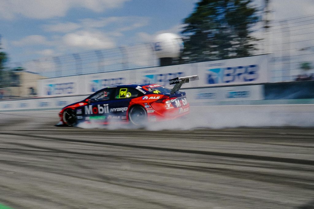 pexels photo 16743653 16743653 Exciting car racing action showcasing speed and motion on a sunny day track.