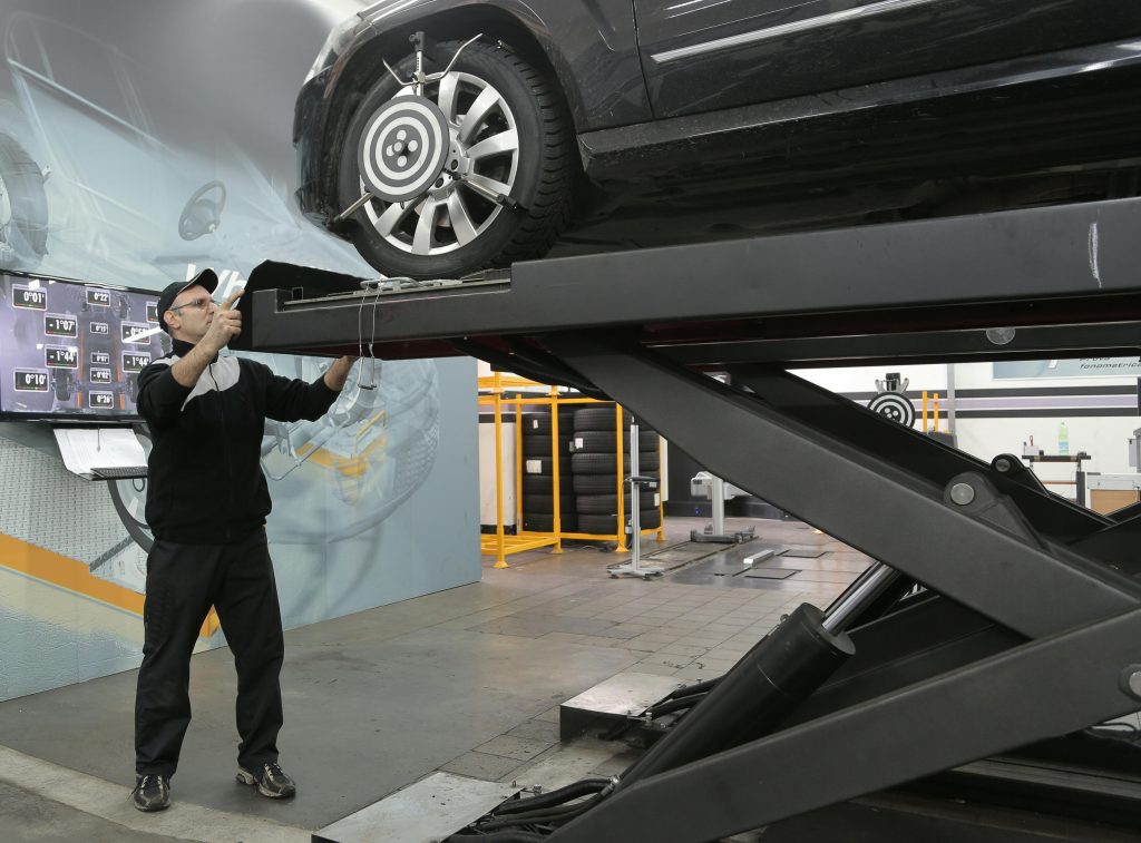 pexels photo 3807799 3807799 Mechanic carefully examining car on hydraulic lift in automotive workshop, ensuring safety and performance.