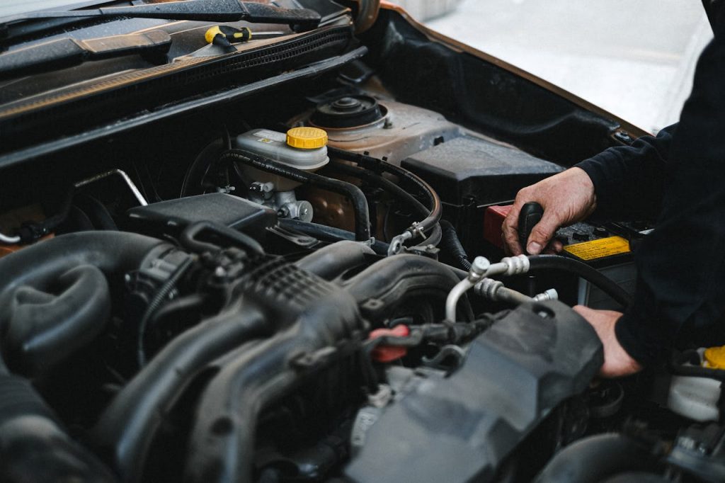 pexels photo 4315575 Close-up of a mechanic's hands working on a car engine, showcasing repair work.