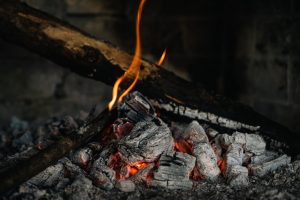 A detailed view of hot embers and burning firewood, creating a warm atmosphere.