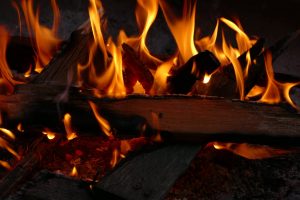 A dynamic close-up shot capturing the vibrant flames of a campfire, emphasizing the warmth and energy of the burning wood.