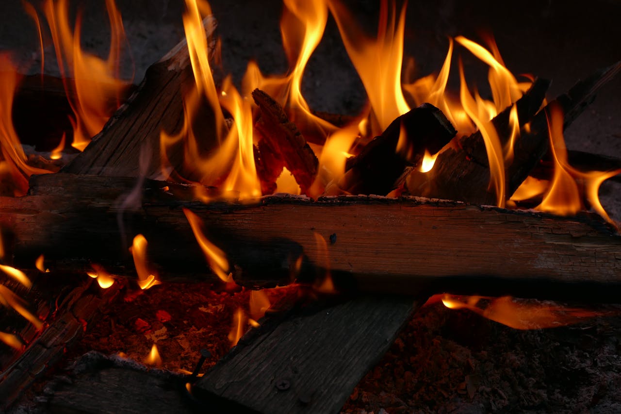 A dynamic close-up shot capturing the vibrant flames of a campfire, emphasizing the warmth and energy of the burning wood.