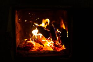 Close-up of burning firewood inside a cozy indoor fireplace. Perfect for winter themes.