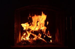 Cozy close-up of a warm, crackling fireplace burning bright wood logs.